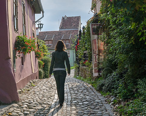 Woman Walking on a Cobblestone Street